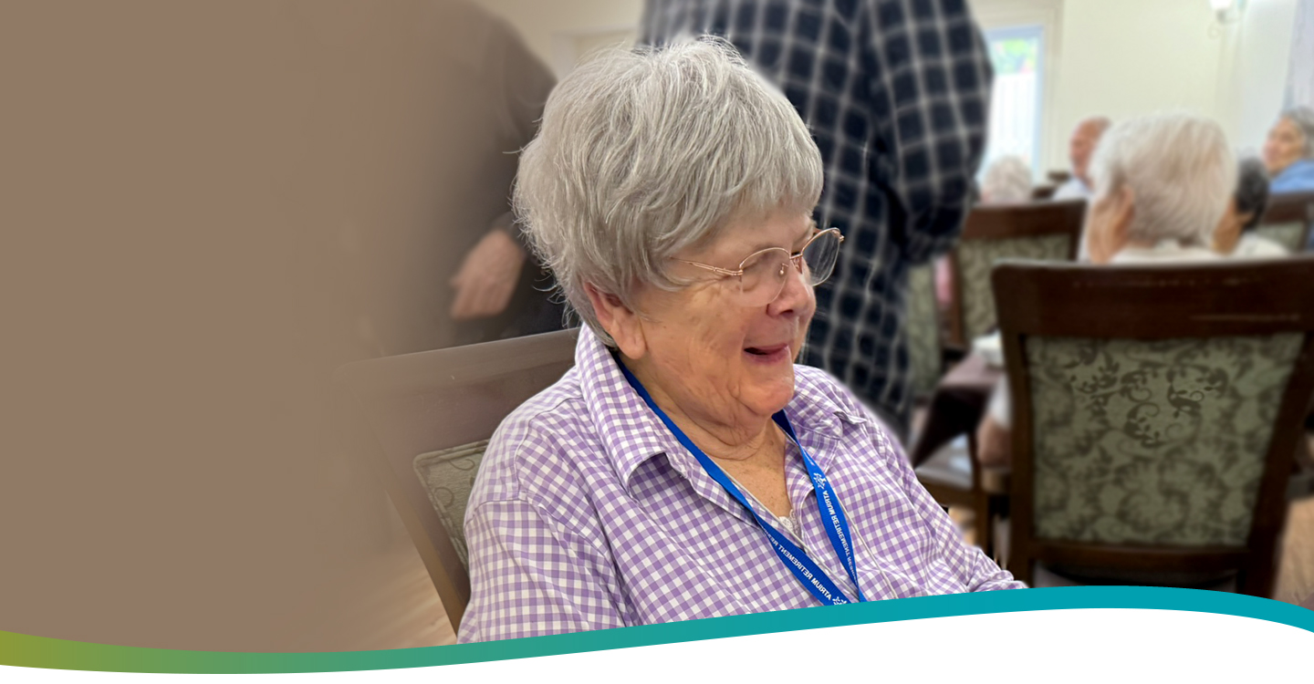 Resident Darlene sitting in the dining room at Atrium Retirement Residence in Orillia, enjoying a relaxed afternoon.